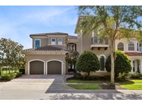 Luxury home with two-car garage and manicured landscaping at 415 Muirfield Loop, Reunion, FL 34747