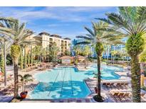 Resort-style pool with lounge chairs and palm trees at 12544 Floridays Resort Dr # 203-B, Orlando, FL 32821