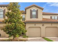 Townhouse exterior with two-car garage and lush landscaping at 8110 Roseville Rd, Davenport, FL 33896