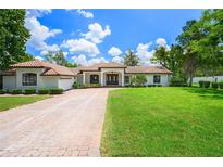 Single story home with tile roof and brick driveway at 325 Magnolia St, Windermere, FL 34786