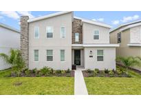 Modern two-story home with stone accents and landscaping at 9106 Sommerset Hills Dr, Davenport, FL 33896