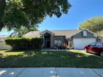 Gray house with a brick facade, landscaped yard, and two-car garage at 1046 Shinnecock Hills Dr, Oviedo, FL 32765