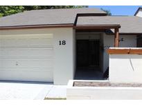 Condo exterior with a white garage door and landscaping at 2681 Washington Ave # 18, Eustis, FL 32726