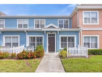 Charming two-story home with blue siding and white picket fence at 2213 San Vittorino Cir # 106, Kissimmee, FL 34741