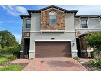 Two-story townhome with a two-car garage and brick driveway at 8502 Arcadia Ln, Davenport, FL 33896