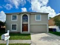 Two story house with a double car garage and manicured lawn at 104 Richmar Ave, Haines City, FL 33844