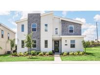 Modern two-story home with stone accents and landscaped yard at 9076 Sommerset Hills Dr, Davenport, FL 33896