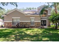Two-story house with stone accents and solar panels at 1301 Kintla Rd, Apopka, FL 32712