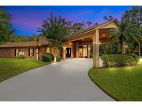 Brick house with porte-cochere and landscaped yard at 2083 Biltmore Pt, Longwood, FL 32779