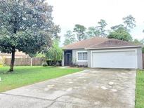 Single-story home with a driveway and well-maintained lawn at 605 Oakpoint Cir, Davenport, FL 33837