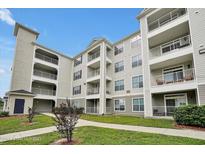 Three-story building exterior with landscaped grounds at 3174 Feltrim Pl # 104, Kissimmee, FL 34747