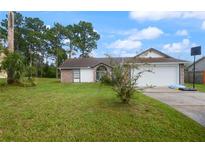 Brick house with a white garage door and a basketball hoop in the yard at 2921 Omaha Dr, Deltona, FL 32738