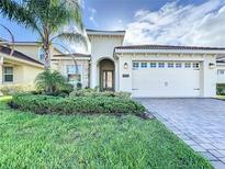 Two-story home with a two-car garage and manicured lawn at 1065 Blackwolf Run Rd, Davenport, FL 33896