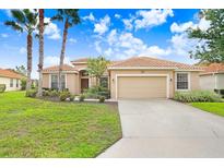 Tan one-story house with tile roof and two-car garage at 4080 Oaktree Dr, Davenport, FL 33837