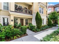 Tan townhome with balcony, landscaping, and sidewalk at 3136 Porta Romano Way, Lake Mary, FL 32746