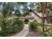 Front entry with a walkway, lush landscaping, and a rustic fence at 5006 Cub Lake Dr, Apopka, FL 32703