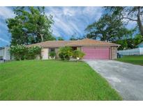 Brick ranch home with pink garage door at 5924 White Egret Ln, Orlando, FL 32810