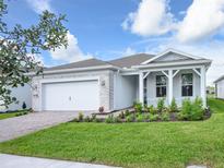 One-story home with white siding, stone accents, and a covered porch at 2476 Pine Preserve Ct, St Cloud, FL 34771