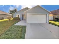 Single-story home with a two-car garage and driveway at 1078 Osprey Cove Cir, Groveland, FL 34736