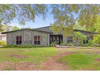 Ranch style home with stone facade, landscaping, and a spacious lawn at 1521 Oxford Rd, Maitland, FL 32751