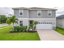 Two-story house with gray siding, white garage door, and landscaping at 14007 Creek Harbor Dr, Orlando, FL 32824