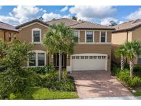 Two story house with a large driveway and palm trees at 8804 Macapa Dr, Kissimmee, FL 34747