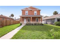 Two-story house with orange exterior and a well-maintained lawn at 1012 S Holly Ave, Sanford, FL 32771