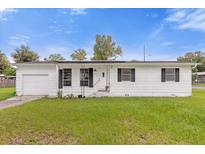 Single story home with a white exterior and attached garage at 354 Park Dr, Deland, FL 32724
