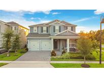 Two-story house with gray siding and two-car garage at 10472 Petrillo Way, Winter Garden, FL 34787