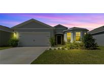 Two-story home with gray siding, white door, and landscaping at 2716 Fieldbrooke Way, Edgewater, FL 32141