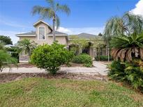 Two-story home with lush landscaping and a spacious front yard at 25013 Derby Dr, Sorrento, FL 32776