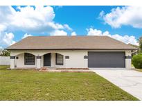 Single story home with a two-car garage at 6585 Whirlaway Cir, Orlando, FL 32818