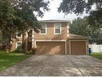 Two-story house with a large driveway and attached garage at 15507 Willet Ct, Mascotte, FL 34753
