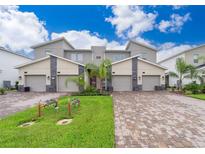 Modern three-unit townhome with driveway and landscaping at 8889 Cabot Cliffs Dr # 104, Davenport, FL 33896
