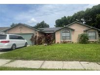 Single-Gathering home with solar panels and green lawn at 5470 Higgins Way, Orlando, FL 32808