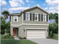 Two story home with two tone exterior, two car garage, and red door at 1955 Hemingway Cir, Groveland, FL 34736