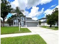 Two-story house with palm trees and driveway at 14534 Potanow Trl, Orlando, FL 32837
