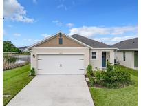 White house with a two-car garage and landscaping at 2222 Elmsford Pt, Sanford, FL 32771
