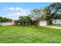 Brick house with a large front yard and a driveway at 1005 Crescent Pkwy, Deland, FL 32724