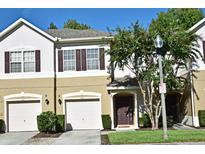 Two-story tan townhome with two-car garage and landscaping at 548 Pinebranch Cir, Winter Springs, FL 32708