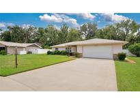 Single-story home with a one-car garage and landscaped lawn at 3472 Country Walk Dr, Port Orange, FL 32129