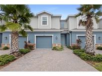 Two-story townhome with gray siding and blue garage doors at 1820 Holden Ridge Ln, Clermont, FL 34715