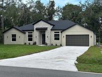 Two-story house with stone accents and a two-car garage at 1420 Lake Harney Rd, Geneva, FL 32732