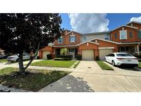 Townhouse exterior with two-car garage and landscaped lawn at 3167 Tocoa Cir, Kissimmee, FL 34746