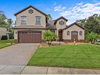 Two story home with brown accents and landscaping at 143 Brunswick Dr, Davenport, FL 33837