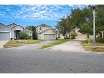 Two-story house with attached garage and a well-maintained lawn at 13950 Morning Frost Dr, Orlando, FL 32828