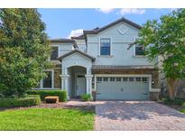 Two-story home with gray siding and brick driveway at 1435 Moon Valley Dr, Davenport, FL 33896