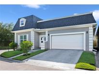 Gray house with white garage door and landscaping at 900 Sussex Close, Orlando, FL 32804