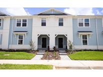 Two-story townhouses with light blue siding and landscaping at 1264 Blue Island Drive, Clermont, FL 34714