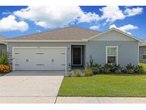 House exterior featuring a two-car garage and well-maintained lawn at 162 Piave St, Haines City, FL 33844